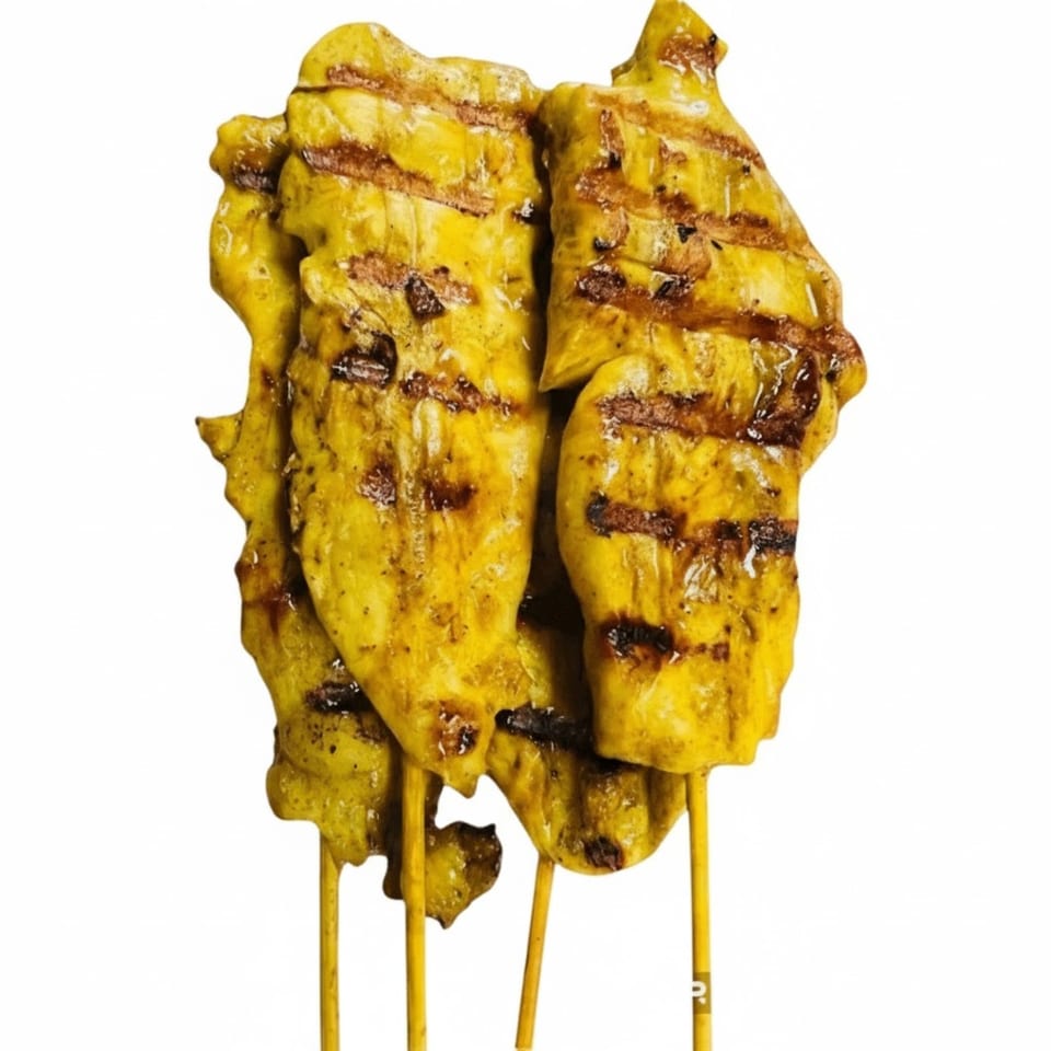 Grilled chicken satay skewers with char marks, marinated in a yellow spice blend.