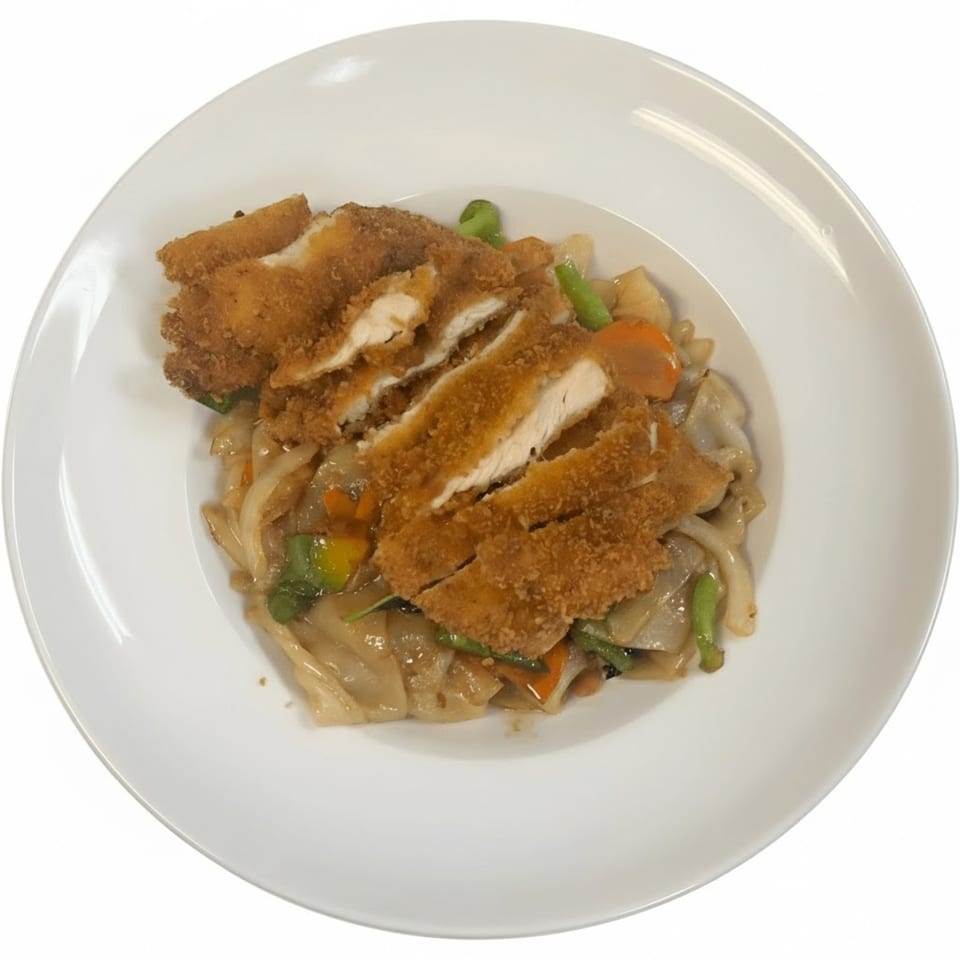 Crispy fried chicken slices over wide rice noodles with vegetables, a Thai dish from Jaidee Thai Restaurant.